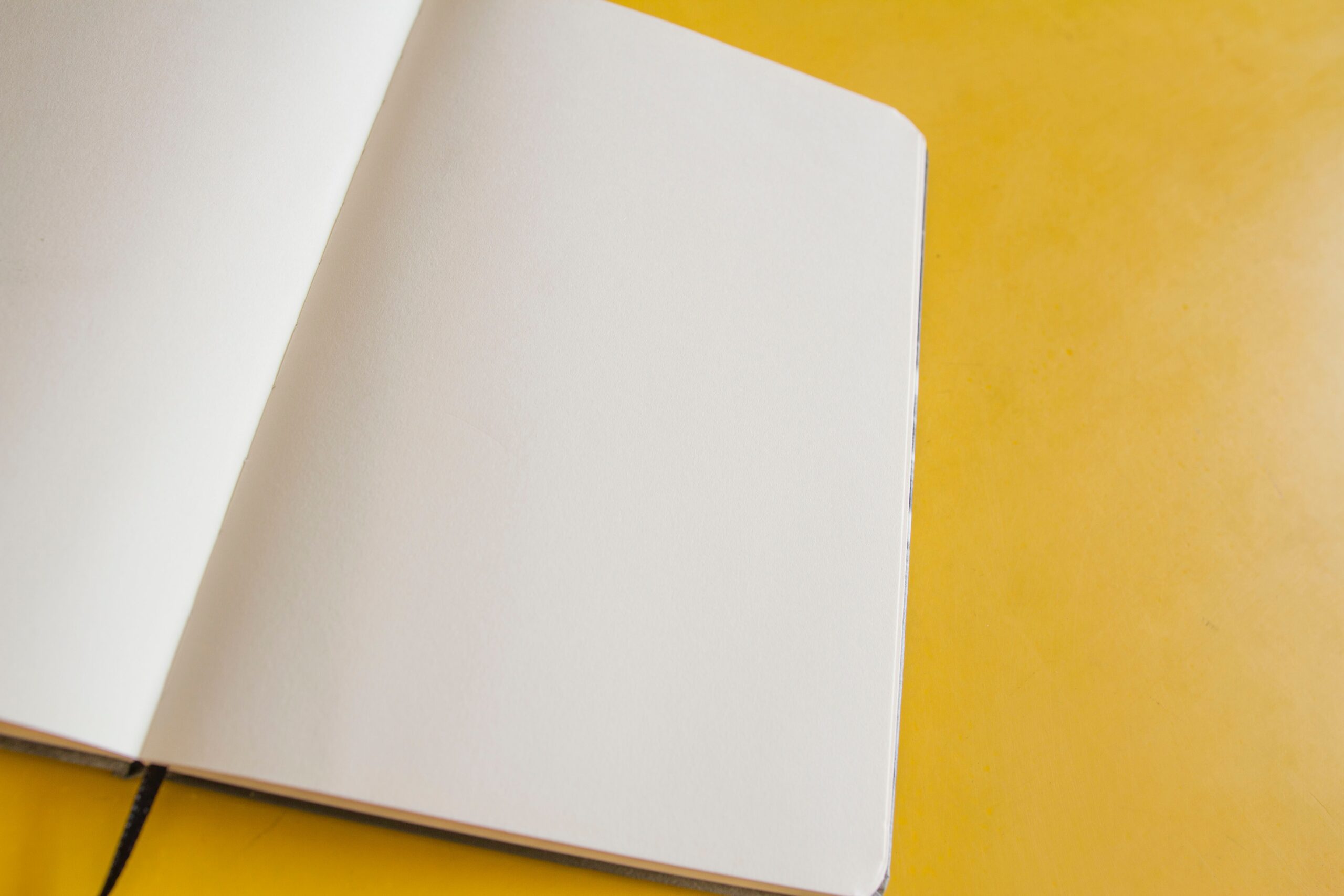 alt="quaderno vuoto su sfondo giallo, consigli per stimolare la creatività"